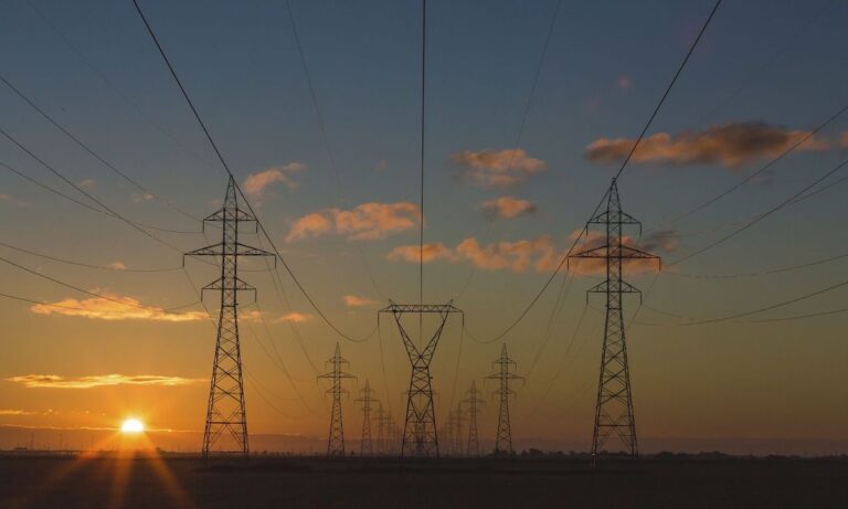 Electricity pylons at sunrise OR sunset, unidentified location. Original public domain image from Wikimedia Commons